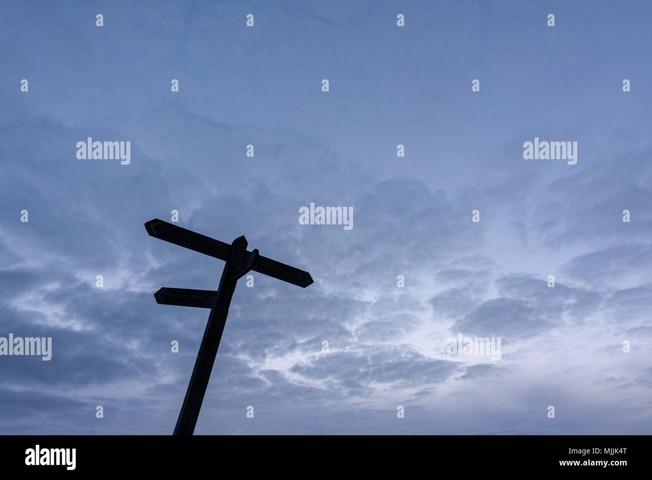 Multi-directional footpath sign post against a dusk glooming sky Stock ...