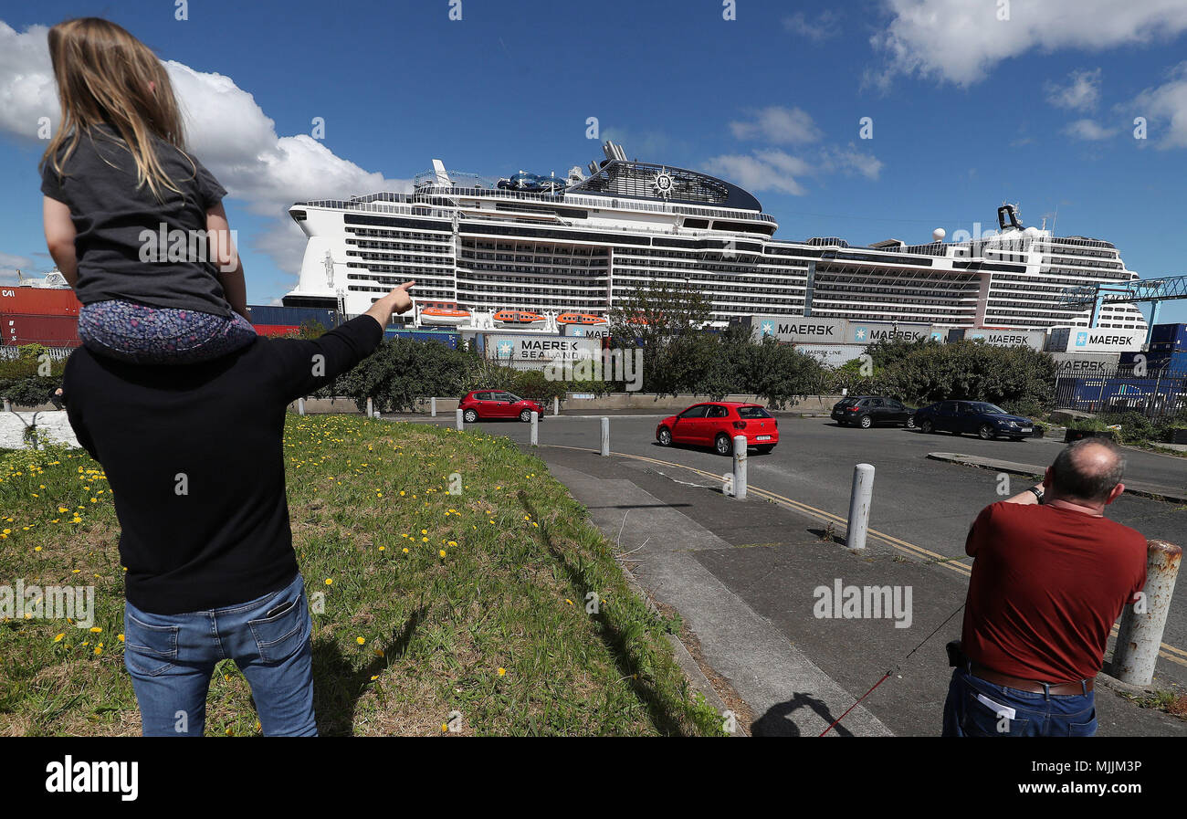 People stop to look at the MSC Meraviglia as it's docked in Dublin during it's maiden call to the city. At 315 metres long and 65 metres tall the ship can hold 5,700 guests making it the largest ever cruise ship (by passenger capacity) to dock in Ireland. Stock Photo