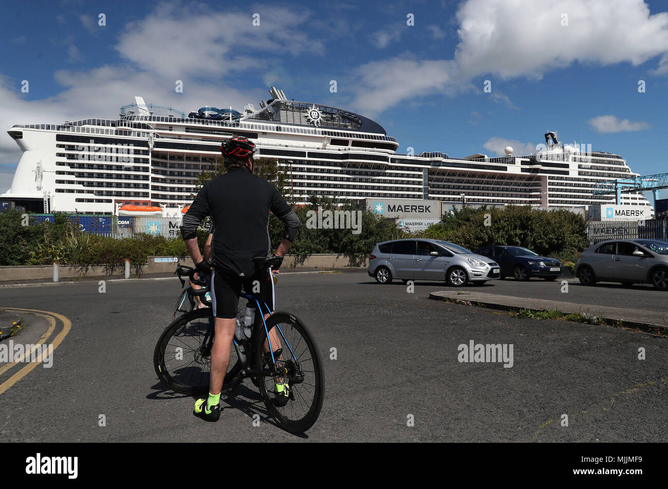 People stop to look at the MSC Meraviglia as it's docked in Dublin during it's maiden call to the city. At 315 metres long and 65 metres tall the ship can hold 5,700 guests making it the largest ever cruise ship (by passenger capacity) to dock in Ireland. Stock Photo