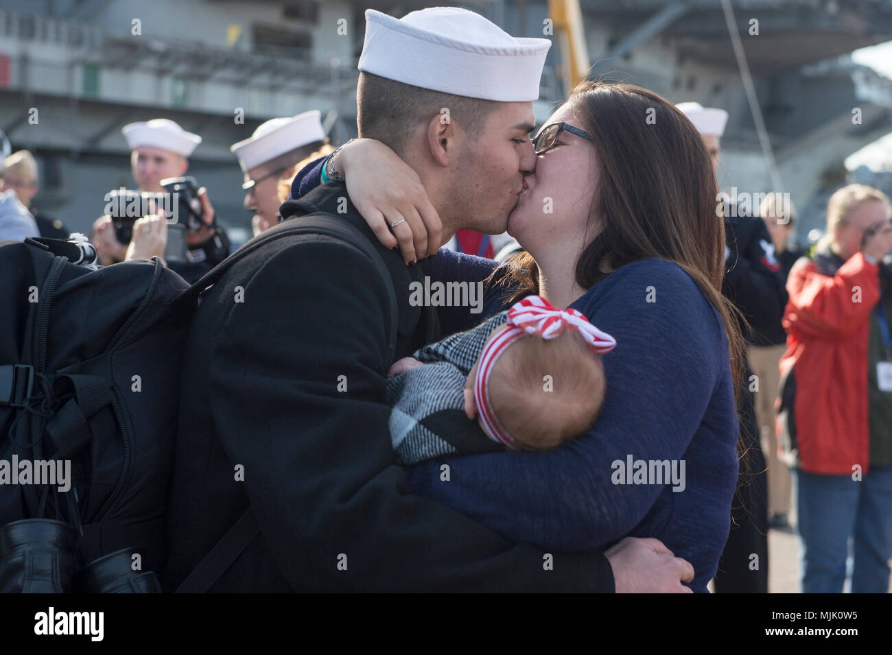 171205-N-BN355-0121  SAN DIEGO (Dec. 05, 2017) A U.S. Navy Sailor greets his wife and daughter after returning from deployment aboard USS Nimitz. The Nimitz Carrier Strike Group is on a regularly scheduled deployment to the Western Pacific. The U.S. Navy has patrolled the Indo-Asia-Pacific region routinely for more than 70 years, prompting peace security. (U.S. Navy photo by Mass Communication Specialist Seaman Apprentice Jailene Casso/Released) Stock Photo