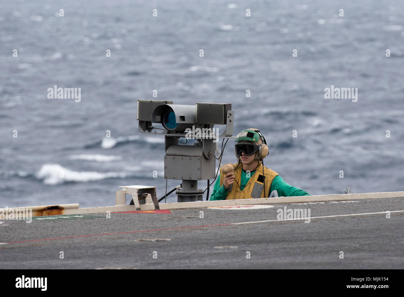 171205-N-EA818-257 ATLANTIC OCEAN (Dec. 5, 2017)  Aviation Boatswain's Mate (Equipment) 3rd Class Nickolas Lim operates a sound-powered telephone on a catwalk off the bow of the flight deck aboard USS Harry S. Truman (CVN 75). Truman is currently underway conducting carrier qualifications in preparation for future operations. (U.S. Navy photo by Mass Communication Specialist 2nd Class Tommy Gooley/Released) Stock Photo