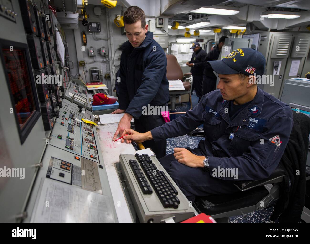 171203-N-KA046-004  MEDITERRANEAN SEA (Dec. 3, 2017) - Gas Turbine Systems Technician (Electrical) Kyle Brown, right, trains Damage Controlman 2nd Class Kristopher Rejcek on the electric plant control console  aboard the Arleigh Burke-class guided-missile destroyer USS Carney (DDG 64), Dec. 3, 2017. Carney, forward-deployed to Rota, Spain, is on its fourth patrol in the U.S. 6th Fleet area of operations in support of regional allies and partners, and U.S. national security interests in Europe. (U.S. Navy photo by Mass Communication Specialist 2nd Class James R. Turner/Released) Stock Photo