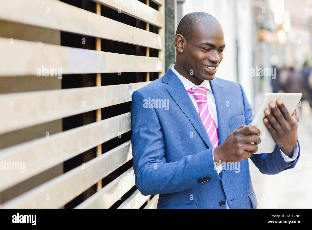 Young black businessman looking at his digital tablet outdoors. Stock Photo