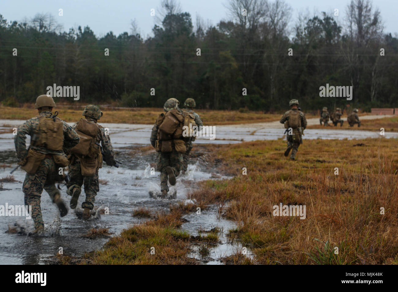 U.S. Marines with Echo Co, Battalion Landing Team, 2nd Battalion, 6th Marine Regiment (BLT 2/6), 26th Marine Expeditionary Unit (MEU), run to secure positions during a simulated raid as part of the amphibious assault which served as the culminating event for the Combined Composite Training Unit Exercise (COMPTUEX) in Camp Lejeune, N.C., Dec. 7, 2017. The exercise allows all elements of the Marine Air Ground Task Force (MAGTF) to join and train in realistic scenarios so the MEU as a whole can meet its Pre-Deployment Training Program objectives prior to their upcoming deployment at sea. (U.S. Ma Stock Photo