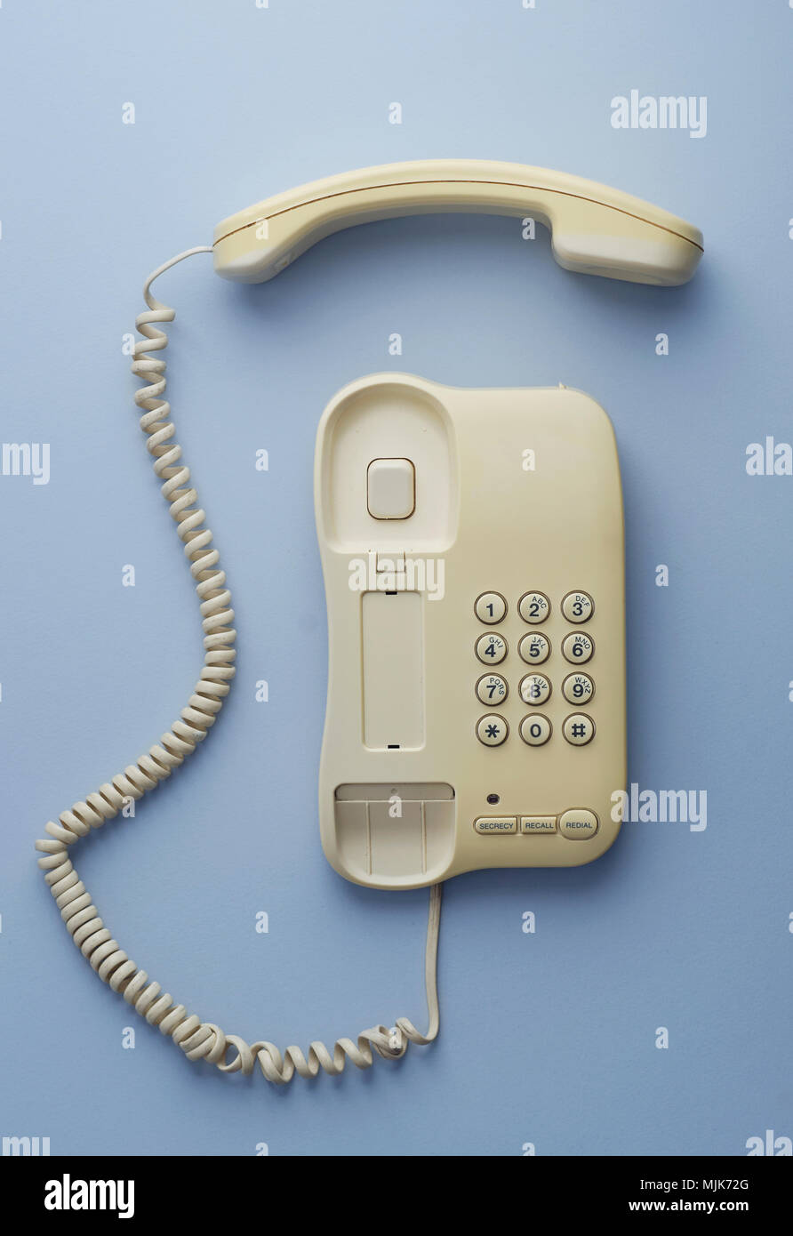 Vintage home telephone over blue background, above view. This image is part of a larger series. Stock Photo