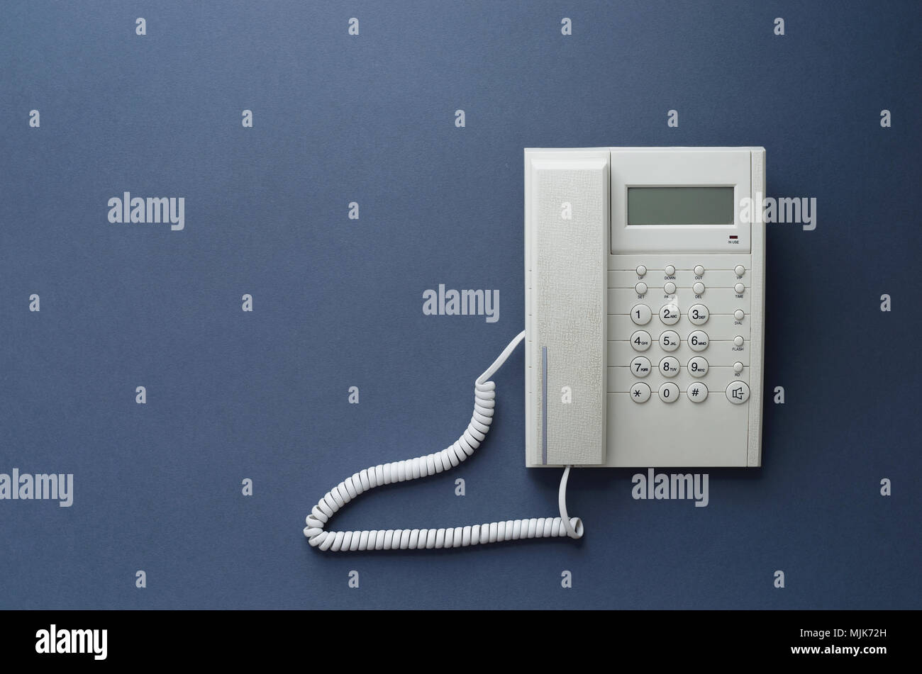 Vintage home telephone over dark blue background, above view. This image is part of a large series. Stock Photo