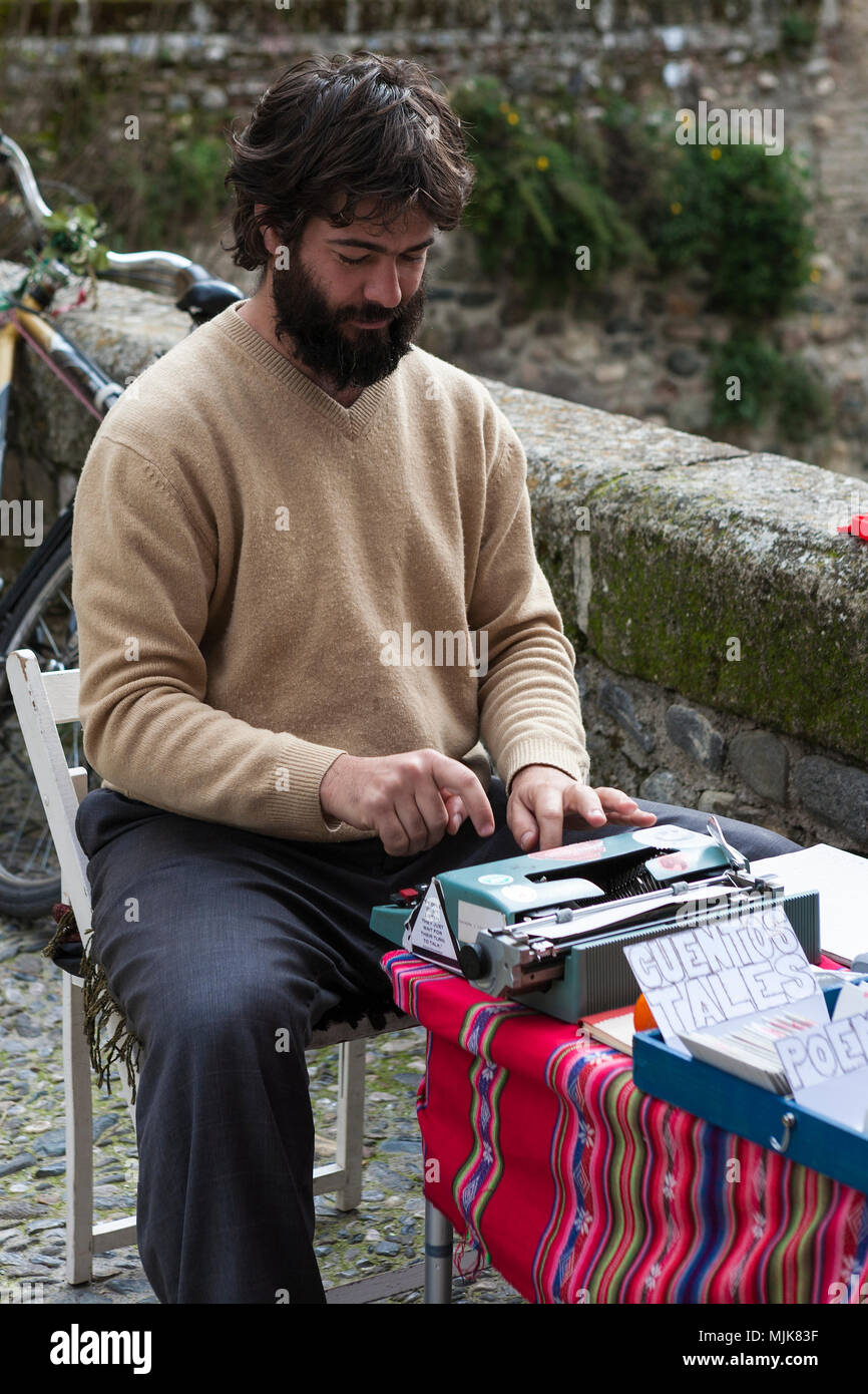 Man typing poems and aphorisms on a manual typewriter, Carrera del Darro, El Albaicín, Granada, Andalucia, Spain Stock Photo