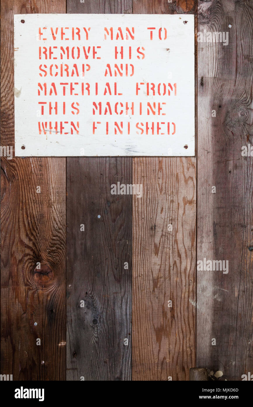 Sign requesting tidiness and efficiency in an old boatbuilding facility Stock Photo