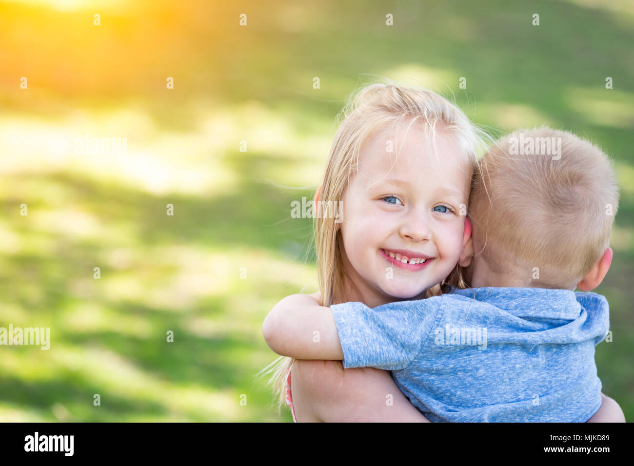 Young Brother and Sister Hugging At The Park Stock Photo - Alamy
