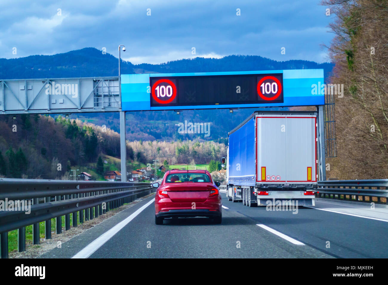 Modern LED traffic signs on highway, red car, truck on road Stock Photo