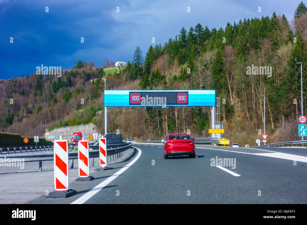 Modern LED traffic signs on highway, red car, truck on road Stock Photo