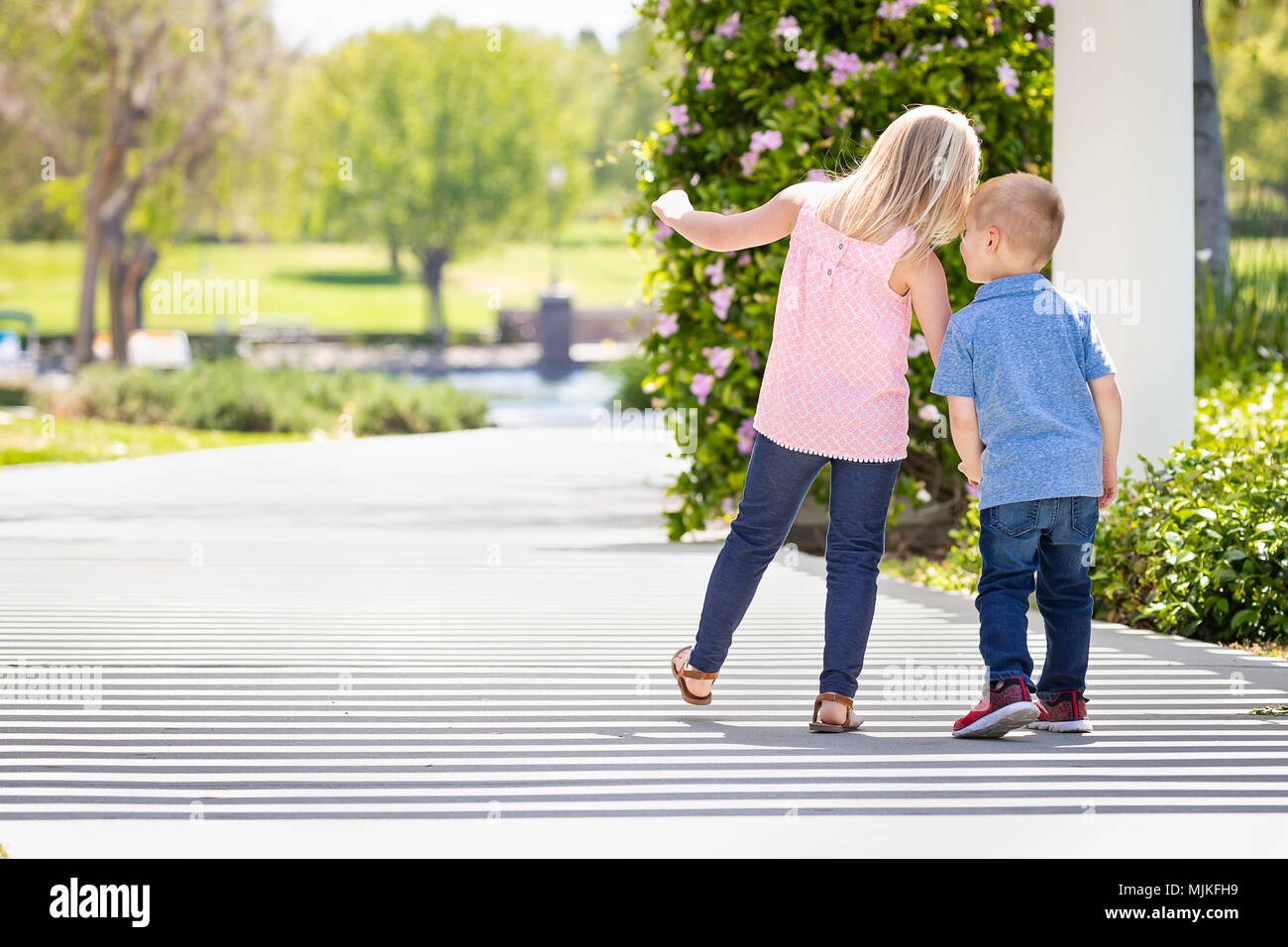 Young Sister and Brother Holding Hands And Walking At The Park Stock ...