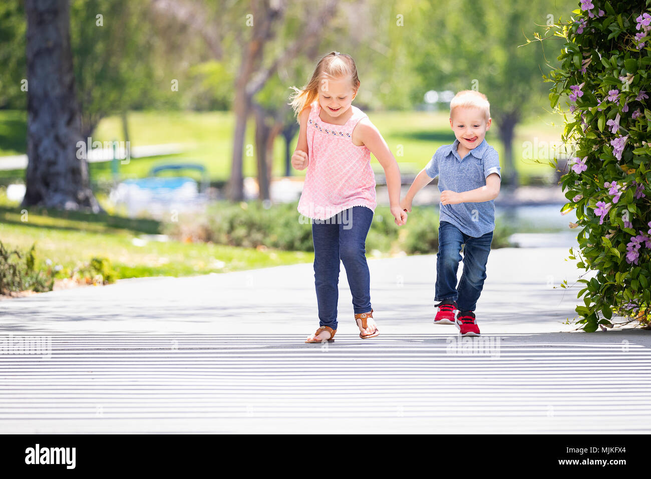 Young Sister and Brother Having Fun Running At The Park Stock Photo - Alamy
