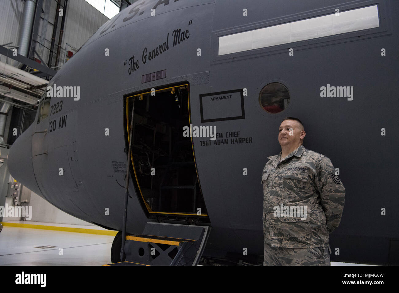 U.S. Air Force Tech. Sgt. Adam Harper, a crew chief for the 130th  Maintenance Group, stands by a C-130H at a plane naming ceremony Dec. 7,  2017 at McLaughlin Air National Guard