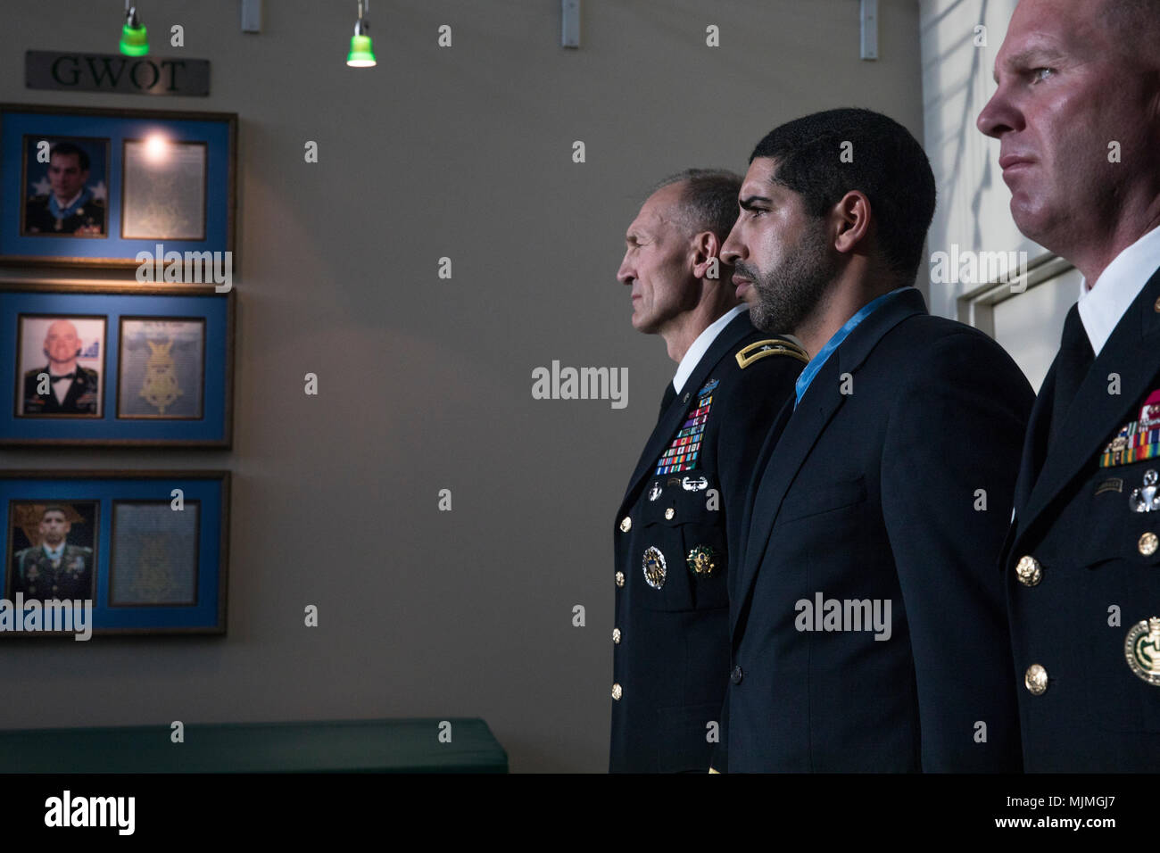 (Left to right) Maj. Gen. Randy A. George, 4th Infantry Division commanding general, Capt. (R) Florent Groberg, Medal of Honor recipient, and Command Sgt. Maj. Timothy Metheny, stand in front of a portrait of Groberg in the 4th Inf. Div. headquarters, Fort Carson, Colo., during the Medal of Honor donation ceremony, December 7, 2017. Both Capt. (R) Flo Groberg and former Staff Sgt. Clint Romesha, 4th Brigade Combat Team Soldiers (now 2nd Infantry Brigade Combat Team, 4th Infantry Division) donated their Medals of Honor to the division. (U.S. Army photo by Sgt. Micah Merrill) Stock Photo