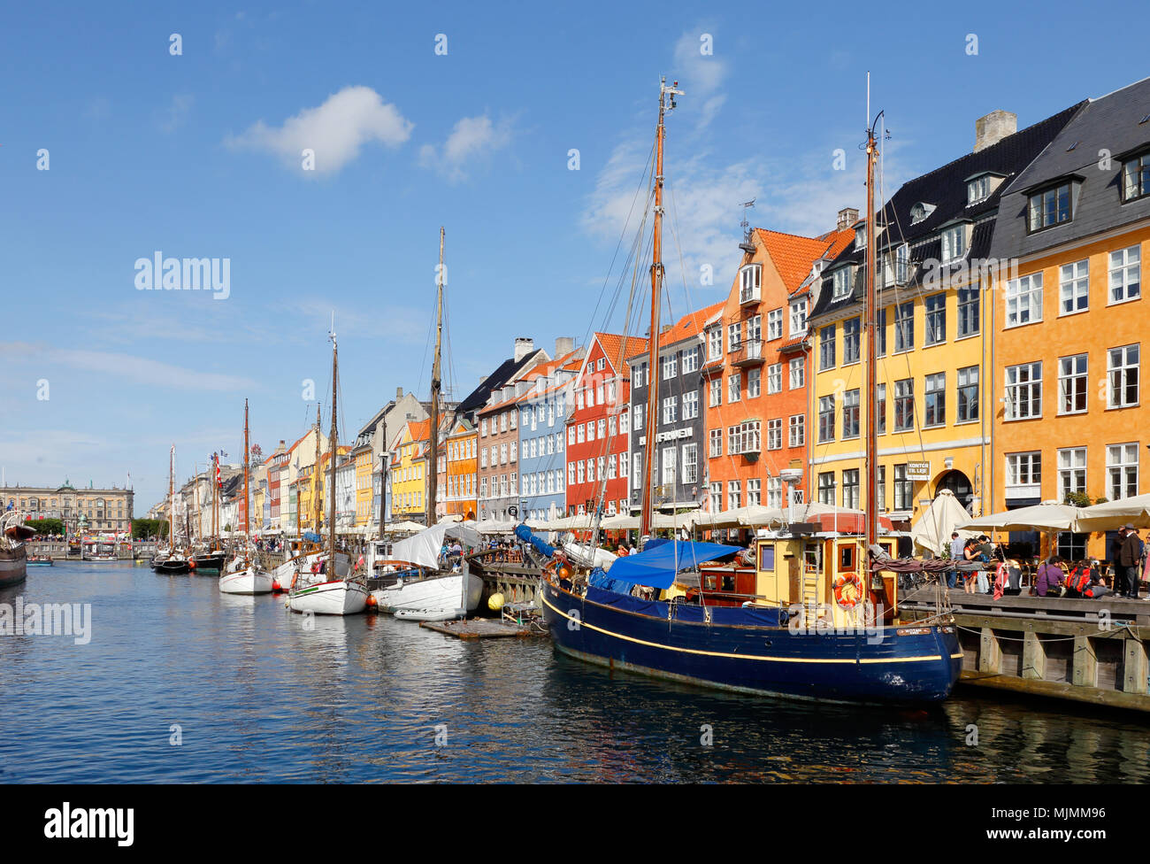 Copenhagen, Denmark - August 24, 2017: View of the canal in front of the colorful buildings with restaurants in Nyhavn. Stock Photo