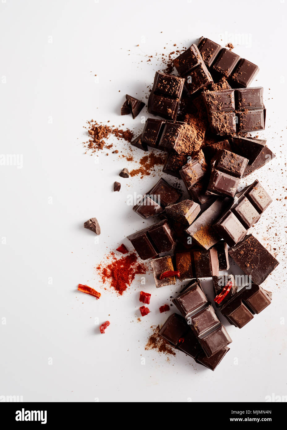 Chunks of dark chocolate with spices on white background. Stock Photo