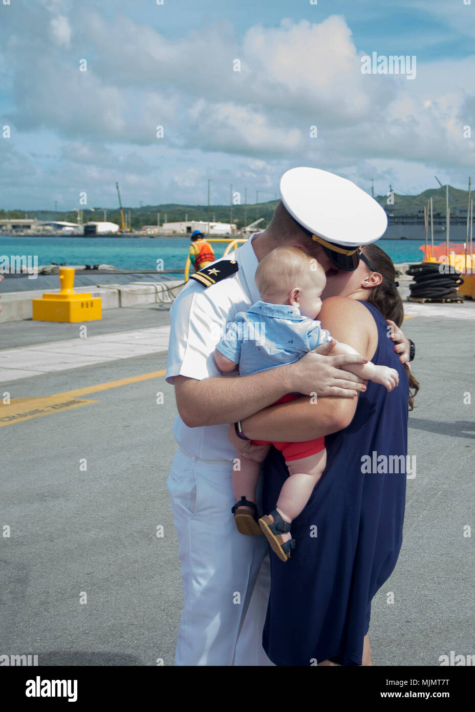 Lt. Jeremiah Roberts, assigned to Los Angeles-class attack submarine USS Asheville (SSN 758), receives the "First Kiss" from his wife Pam and son Joshua during the submarine's arrival celebration at Naval Base Guam. Asheville replaced USS Chicago (SSN 721) as Guam's fourth forward-deployed submarine. (U.S. Navy photo by Culinary Specialist Submarines Seaman Jonathan Perez/RELEASED) Stock Photo
