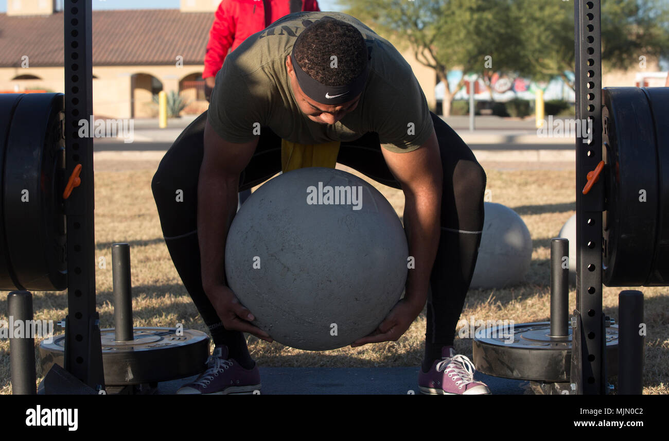 U.S. Marine Corps Sgt. Christopher Deon Fisher Jr., an Aviation Ordnance Technician assigned to Marine Aviation Logistics Squadron 13, stationed at Marine Corps Air Station (MCAS) Yuma, Ariz., lifts an Atlas Stone to practice for the Strongman Competition Dec. 15, 2017 on the station parade deck. Atlas Stones are large balls of concrete used to test strength. The practice is to prepare for the Bull of the Desert Strongman Competition slated Feb. 17, 2018 in Yuma, Ariz. (U.S. Marine Corps photo by Lance Cpl. Sabrina Candiaflores) Stock Photo