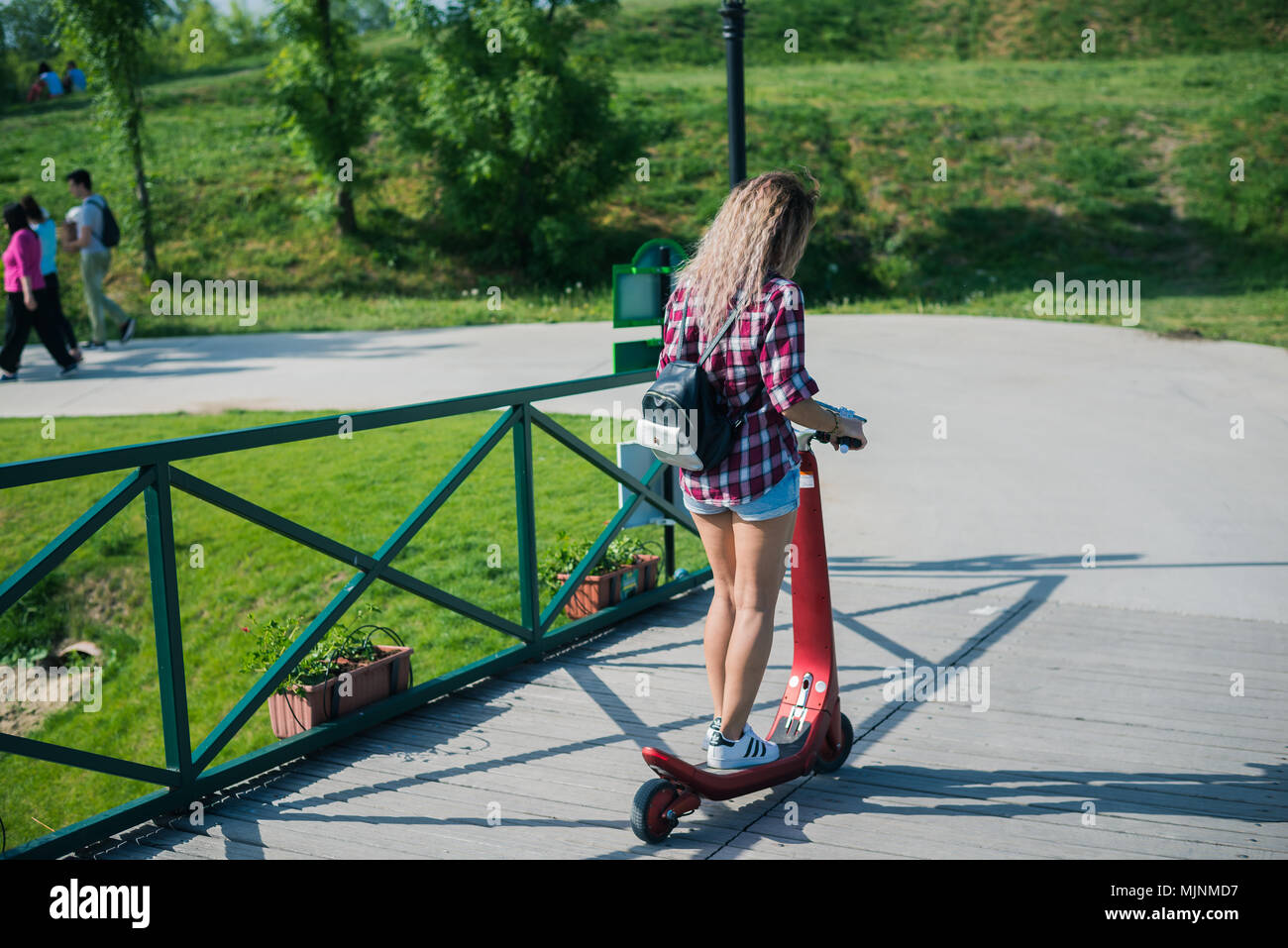 BUCHAREST, ROMANIA, - October 26, 2017: Woman using electric scooter in the park on a sunny day. Illustrative editorial content. Stock Photo