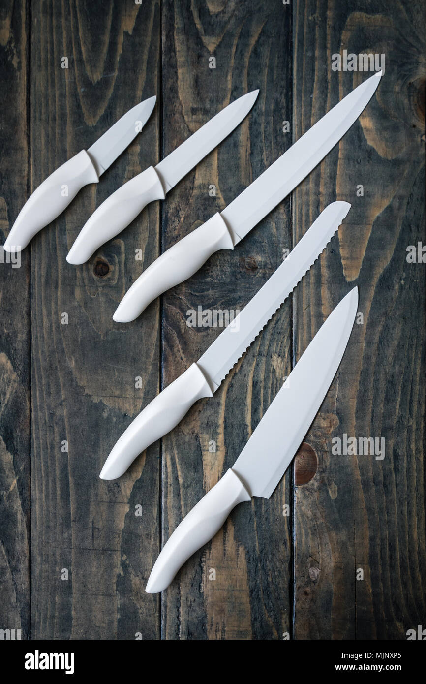 White ceramic chopping knife set on blue wooden background Stock Photo