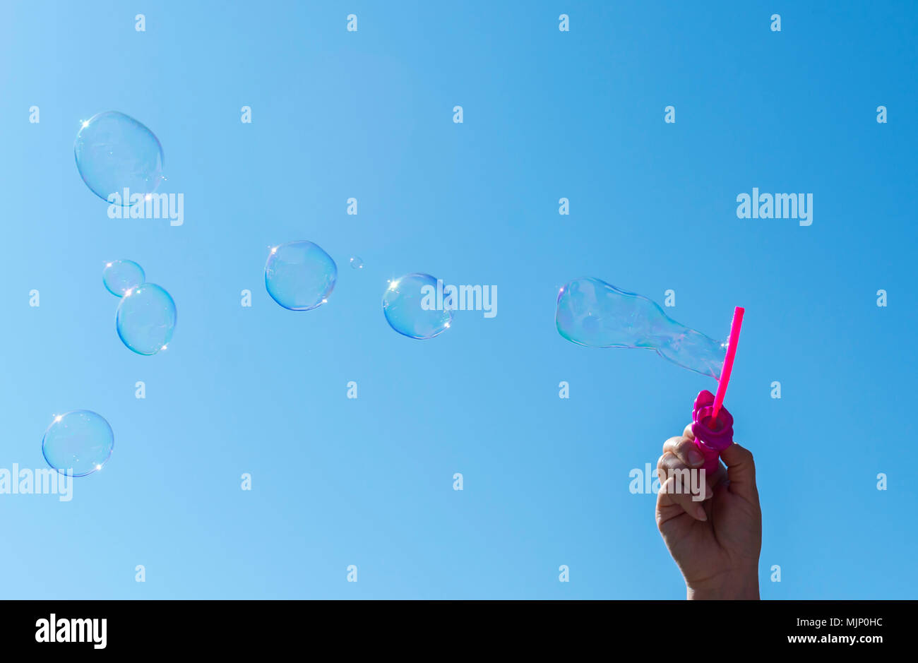 Soap bubbles, Blowing soap bubble on Blue sky background Stock Photo