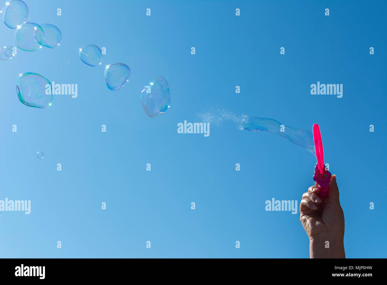 Soap bubbles, Blowing soap bubble on Blue sky background Stock Photo