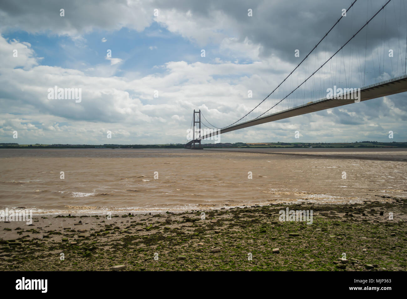Standing on the shore of the humber viewing the humber bridge on a cloudy day Stock Photo
