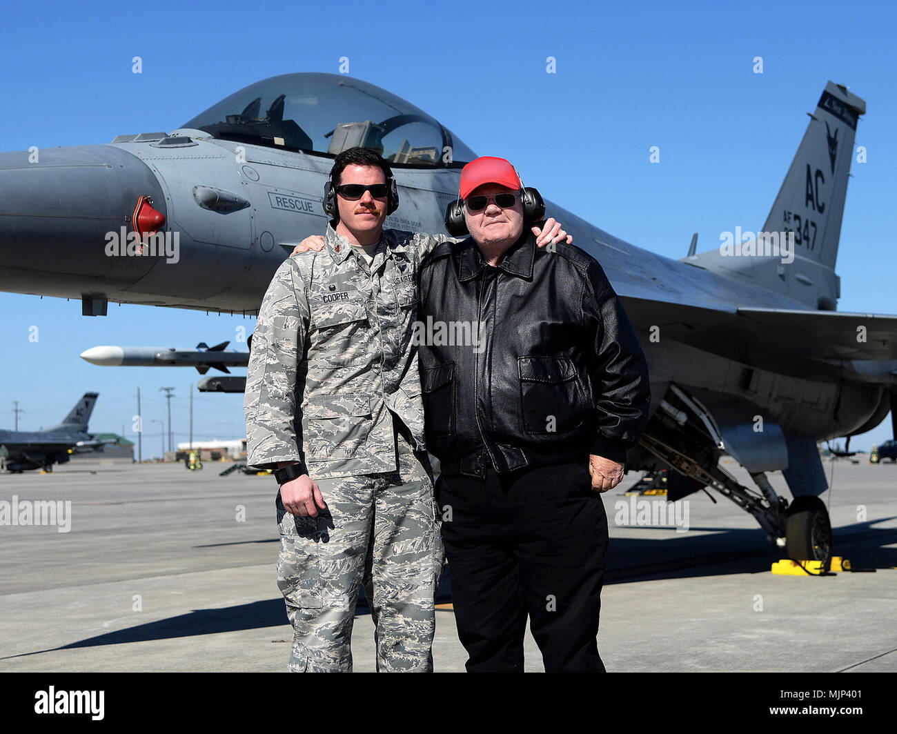Maj. Brian T. Cooper, commander of the 177th Fighter Wing Aircraft Maintenance Squadron, New Jersey Air National Guard, and Thomas J. Cooper, a retired Air Force captain, pose for a photo in front on an F-16C Fighting Falcon at the Air Dominance Center in Savannah, Georgia, March 14, 2018. Brian commissioned in the U.S. Air Force in 2003, almost 40 years after his father Thomas, who commissioned in the Air Force in 1965. Armed Forces and civilians displaying courage bravery dedication commitment and sacrifice Stock Photo