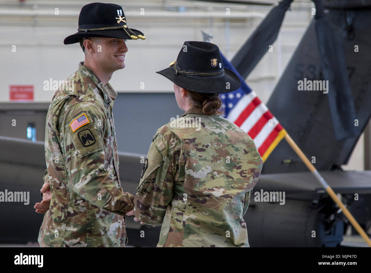 Capt. Jonathan Roberts, E Troop Commander with 4-6 Heavy Attack Reconnaissance Squadron, 16th Combat Aviation Brigade, shakes hands with Capt. Gretchen Gaskins, outgoing commander, after her final speech as the E Troop Commander during the Change of Command Ceremony at Joint Base Lewis-McChord, Wash., March 15, 2018. Gaskins led the Troop during their deployment the previous year. Armed Forces and civilians displaying courage bravery dedication commitment and sacrifice Stock Photo