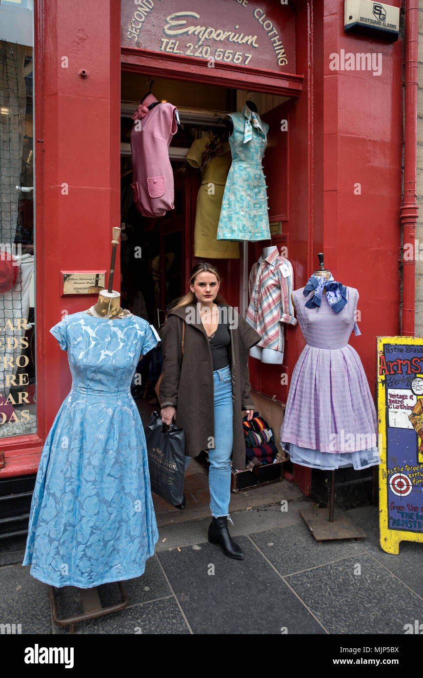 A young woman leaving Armstrong's Vintage Clothing store in the Grassmarket, Edinburgh, Scotland, UK. Stock Photo