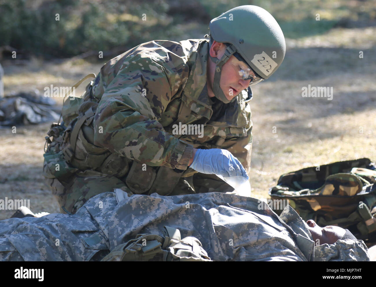 Spc. Matthew Holtz, medic from with 1st Battalion-503rd Infantry Regiment, 173rd Airborne Brigade, treats a penetrating chest wound on a simulated casualty, during U.S. Army Europe's Spring 2018 Expert Field Medical Badge testing, March 20, in Grafenwoehr, Germany. Holtz went on to be recognized as the honor graduate for the testing. Armed Forces and civilians displaying courage bravery dedication commitment and sacrifice Stock Photo