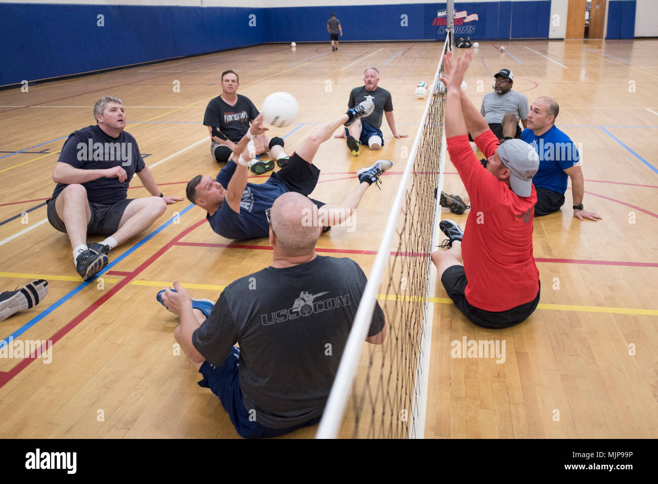 Wounded, ill and injured USSOCOM service members and veterans practice sitting volleyball during training for the 2018 DoD Warrior Games at MacDill Air Force Base in Florida on March 20, 2018.  Participation in USSOCOM Warrior Care Program military adaptive sport events throughout the year enhances SOF athletes' mental and physical rehabilitation, aiding in their reintegration or transition.    (DoD Armed Forces and civilians displaying courage bravery dedication commitment and sacrifice Stock Photo