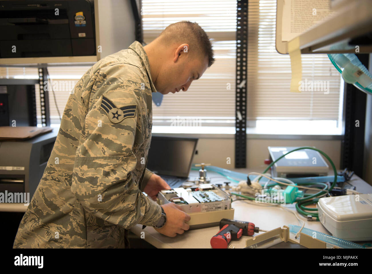 U.S. Air Force Senior Airman Randy Maldonado, 18th Medical Group biomedical equipment technician, assembles a portable ventilator March 21, 2018, at Kadena Air Base, Japan. Portable ventilators are often used by medical support teams and pararescue Airmen in areas that a normal ventilator would not be able to reach, such as in certain types of aircraft or a field environment. Armed Forces and civilians displaying courage bravery dedication commitment and sacrifice Stock Photo