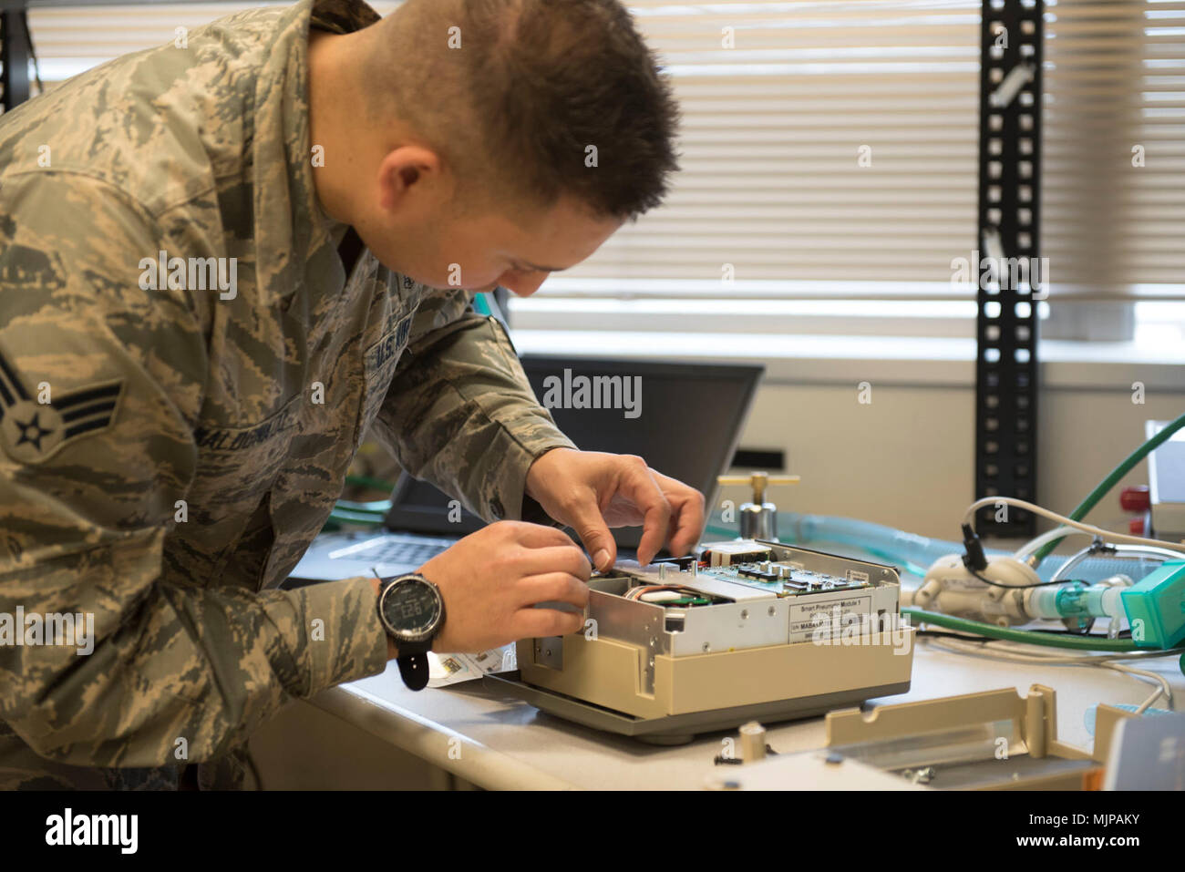 U.S. Air Force Senior Airman Randy Maldonado, 18th Medical Group biomedical equipment technician, assembles a portable ventilator March 21, 2018, at Kadena Air Base, Japan. A centrifuge is used to separate the different components within a blood sample. This allows technicians to test the appropriate areas for more intricate procedures. Armed Forces and civilians displaying courage bravery dedication commitment and sacrifice Stock Photo