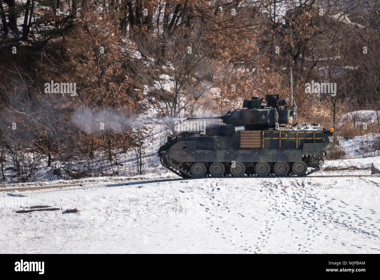 RODRIGUEZ LIVE FIRE COMPLEX, Republic of Korea – A M2A3 Bradley Fighting Vehicle (BFV) from Company A, 4th Squadron, 9th Cavalry Regiment, 2nd Armored Brigade Combat Team, 1st Cavalry Division fires its main 25mm weapon during Gunnery Qualification Table VI on December 13, 2017. Gunnery Qualification Table VI helps the Bradley crews hone their skills as a team and prepare them for further gunnery qualification tables to come. 4-9 Cav. is part of the 2nd Infantry Division’s armored brigade combat team currently stationed in South Korea on a 9-month rotation. Stock Photo