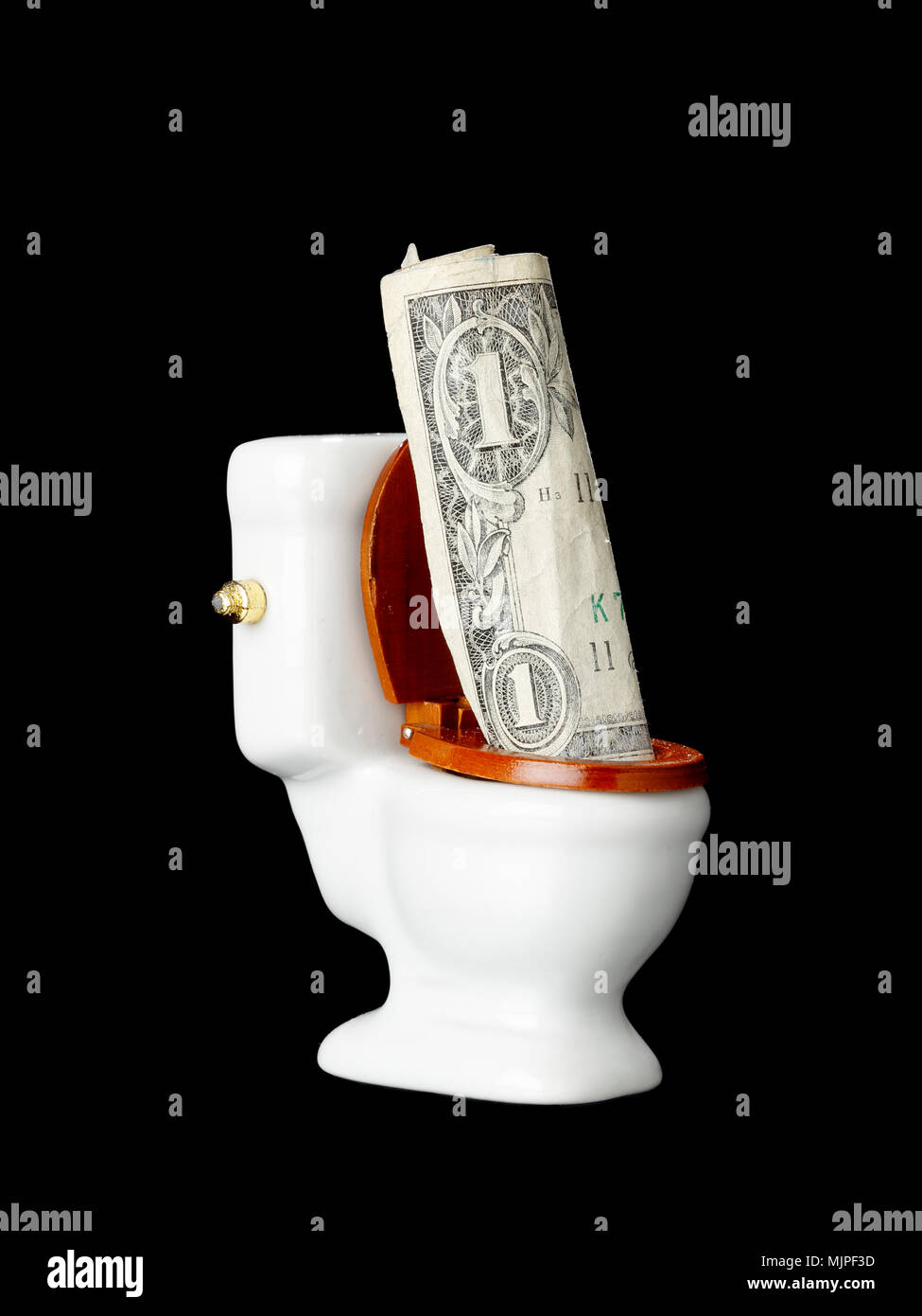 One US one dollar bill  in the toilet isolated on black. Stock Photo