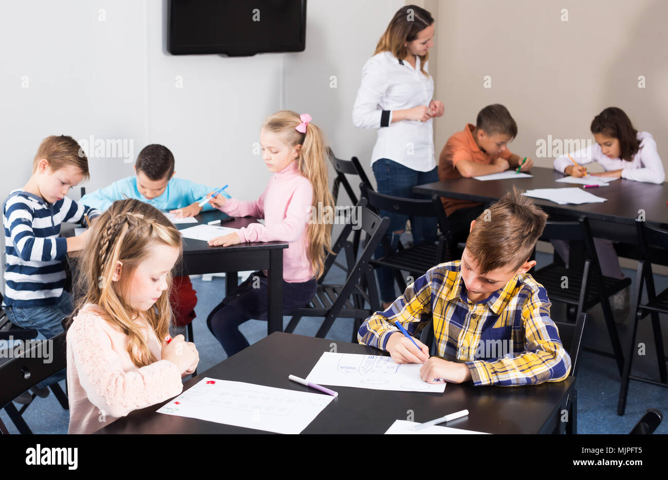 Professor and elementary age children drawing at class Stock Photo - Alamy