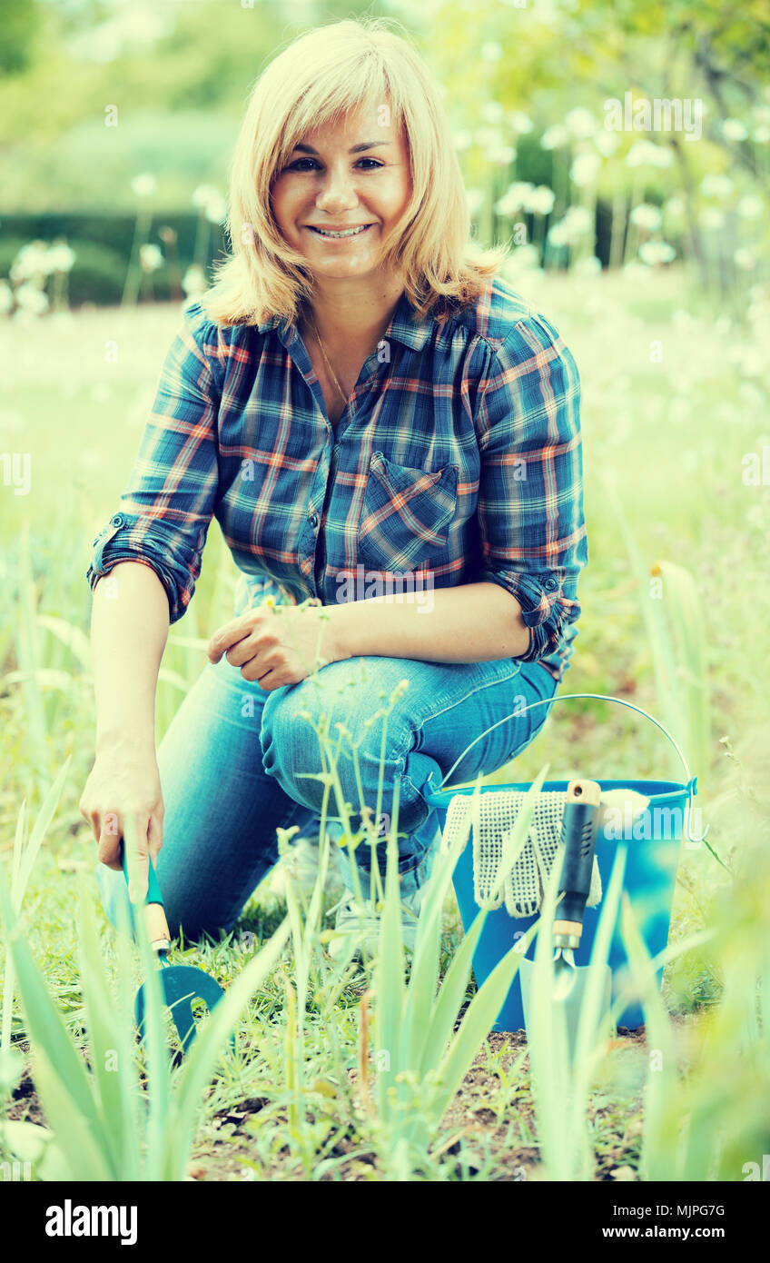 portrait of cheerful mature woman gardening green plants outdoors Stock ...