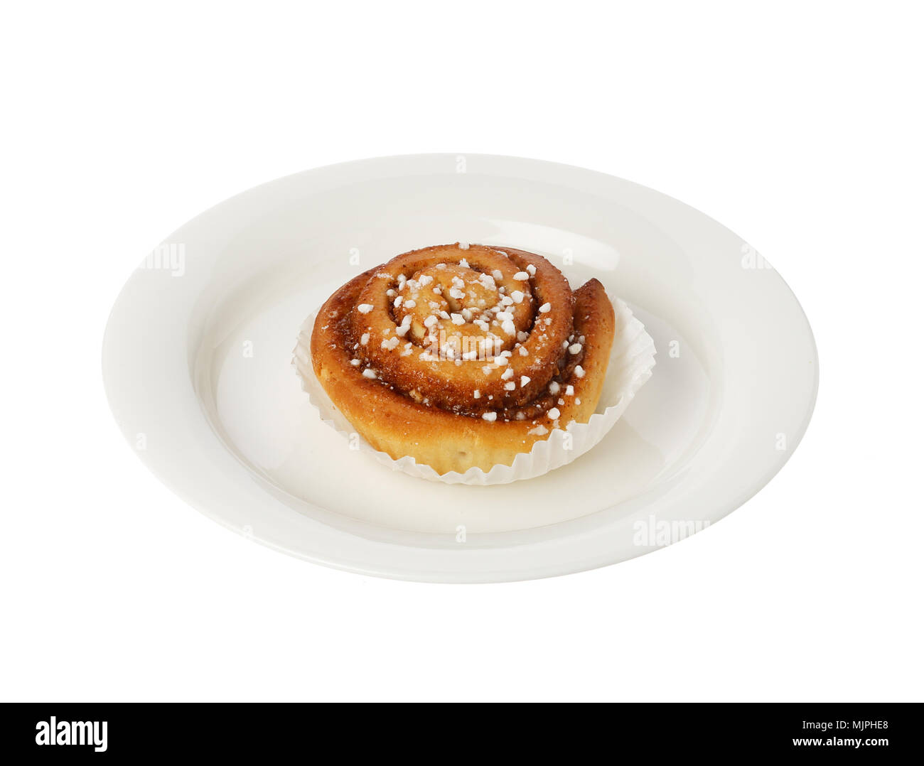 Cinnamon bun on a small plate isolated on white. Stock Photo