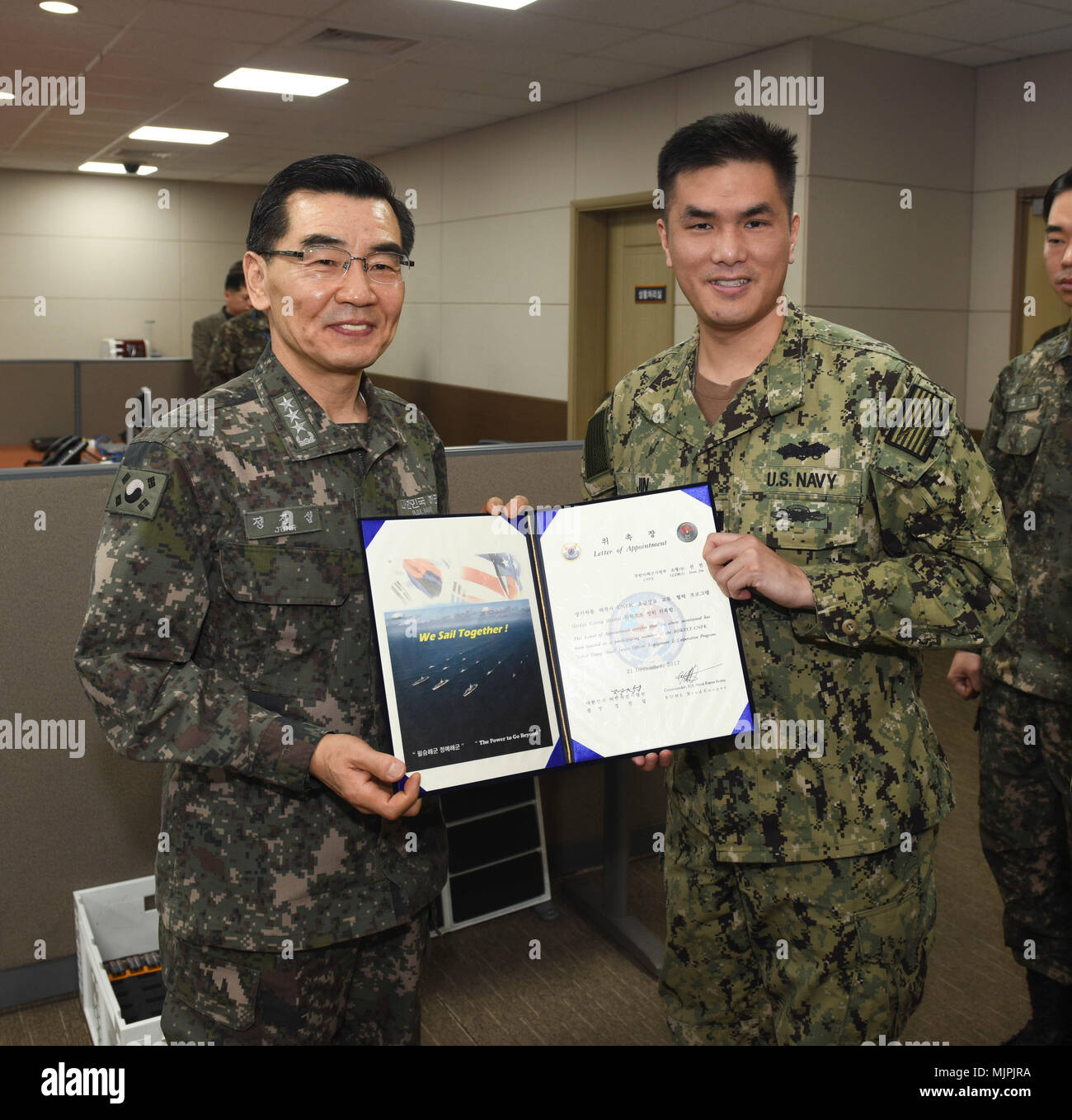 171221-N-TB148-005 BUSAN, Republic of Korea (Dec. 21, 2017) Republic of Korea (ROK) Navy Vice Adm. Jung, Jin-Sup, commander, ROK Fleet, presents Lt.  Sean Jin with a letter of appointment for his selection to the 'Great Young Minds' Junior Officers' Engagement and Cooperation Program. The 'Great Young Minds' initiative brings together hand-selected, young officers from the ROK and U.S. navies and challenges them to develop innovative solutions to further enhance the ROK -U.S. alliance of the future. (U.S. Navy photo by Mass Communication Specialist Seaman William Carlisle) Stock Photo