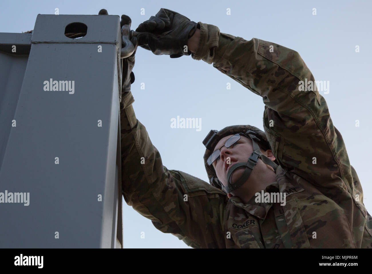 U.S. Army Soldier, Vertical PLT, 643rd ESC, 11th Engineer Battalion hooks conex to crane in South Korea, Dec. 14, 2017. A conex box was created during the Korean War and is used for accomendations for soldiers. (U.S. Army photo by Pfc. Isaih Vega) Stock Photo