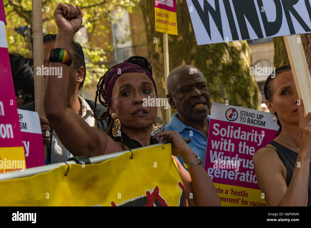 London, UK. 5th May 2018. A woman raises her fist at the Stand Up To Racism rally at Downing St calling for Theresa May's racist 2014 Immigration Act to be repealed and an immediate end to the deportation and detention of Commonwealth citizens, with those already deported to be bought back to the UK. The protesters called for protection to the guaranteed for all Commonwealth citizens and for those affected to be compensated for deportation, threats of deportation, detention, loss of housing, jobs, benefits and denial of NHS treatment. There should be an end to the 'hostile environment' for all Stock Photo