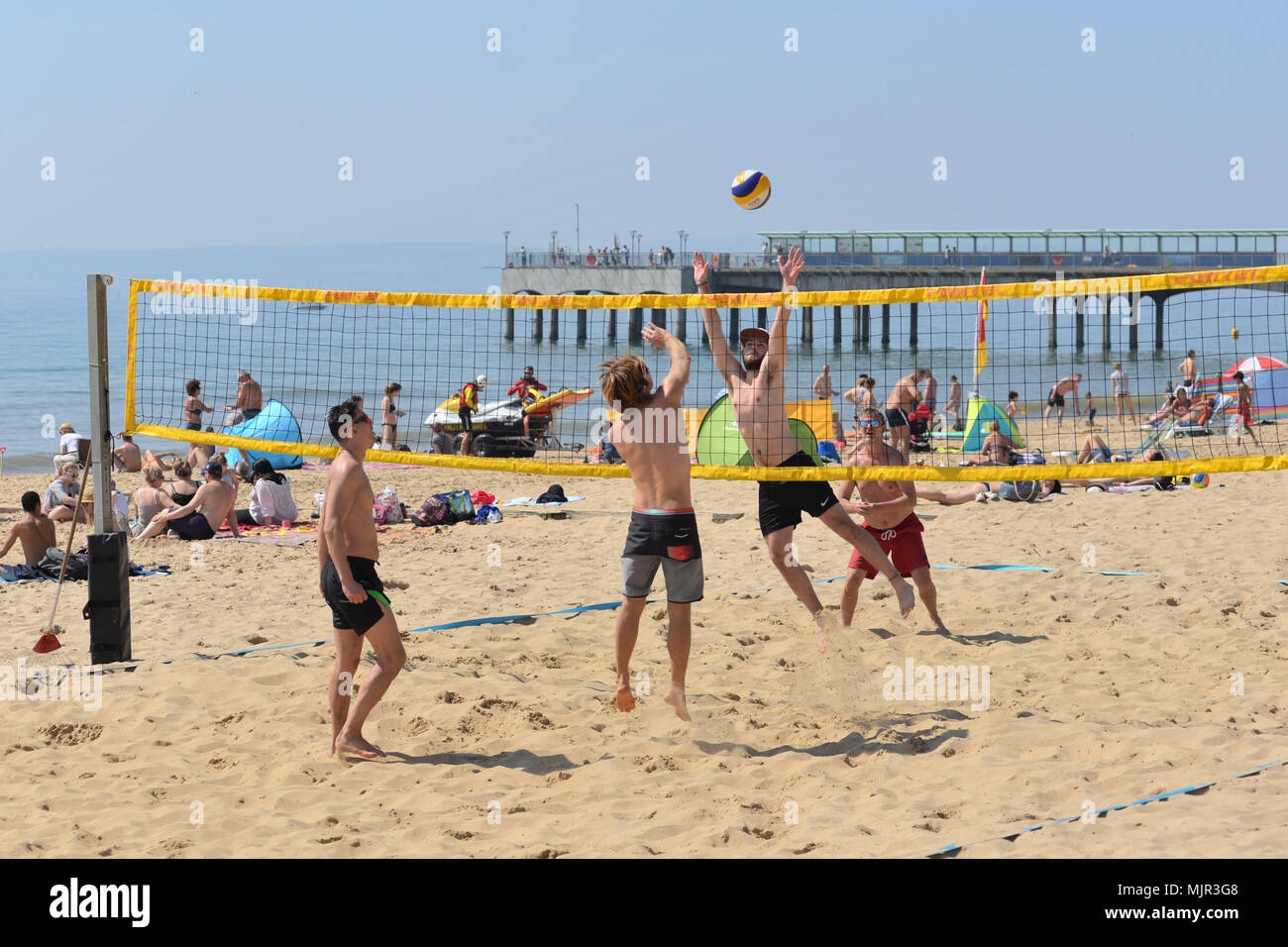 Boscombe, Bournemouth, Dorset, UK, 6th May 2018, Weather: Morning sunshine on the south coast on what could be the hottest Mayday bank holiday weekend on record. Young men playing beach volleyball in perfect conditions. Stock Photo