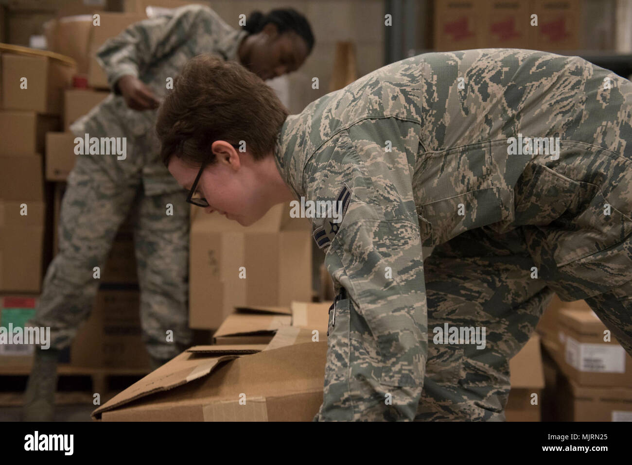 U.S. Air Force Airman 1st Class’ Ashley Cromwell, left, and Gabrielle McDowell, right, both 18th Medical Group medical material technicians, stack boxes of medical supplies for palletizing March 21, 2018, at Kadena Air Base, Japan. Many items, such as first-aid kits and medications, must be checked for quality before they can leave the warehouse. Armed Forces and civilians displaying courage bravery dedication commitment and sacrifice Stock Photo