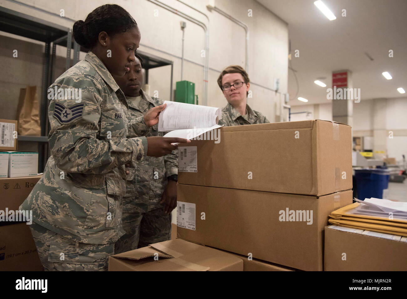 U.S. Air Force Staff Sgt. Sha’leah Paul, left, Airman 1st Class’ Ashley Cromwell, center, and Gabrielle McDowell, right, all 18th Medical Group medical material technicians, review a list of medical materials March 21, 2018, at Kadena Air Base, Japan. Many items, such as first-aid kits and medications, must be checked for quality before they can leave the warehouse. Armed Forces and civilians displaying courage bravery dedication commitment and sacrifice Stock Photo