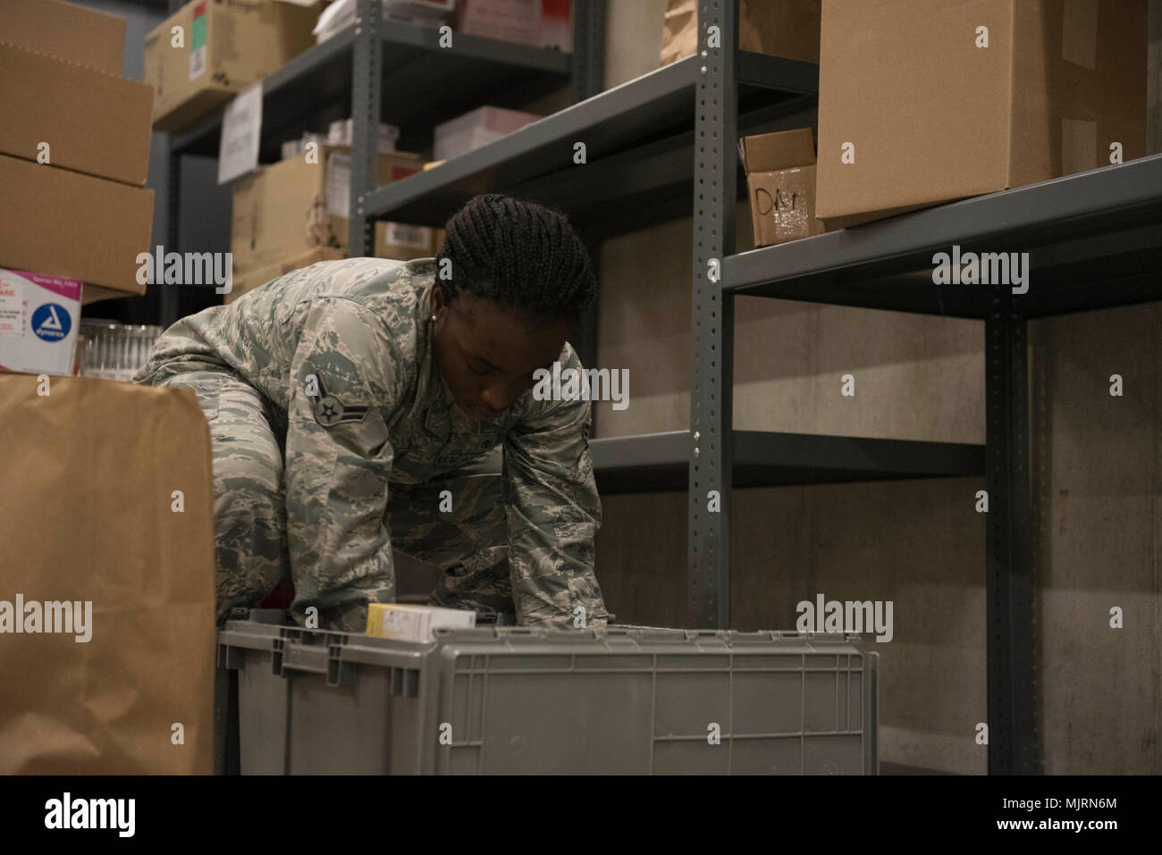 U.S. Air Force Airman 1st Class Ashley Cromwell, 18th Medical Group medical material technician, checks the contents of a crate March 21, 2018, at Kadena Air Base, Japan. Medical materials go through the warehouse managed by the 18th MDG “Log Dogs” before being distributed throughout units both in and outside the medical group building. Armed Forces and civilians displaying courage bravery dedication commitment and sacrifice Stock Photo