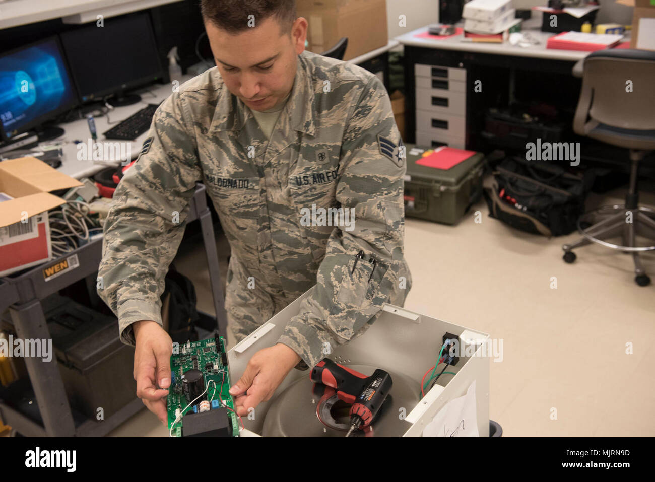 U.S. Air Force Senior Airman Randy Maldonado, 18th Medical Group biomedical equipment technician, repairs a centrifuge March 21, 2018, at Kadena Air Base, Japan. Portable ventilators are often used by medical support teams and pararescue Airmen in areas that a normal ventilator would not be able to reach, such as in certain types of aircraft or a field environment. Armed Forces and civilians displaying courage bravery dedication commitment and sacrifice Stock Photo