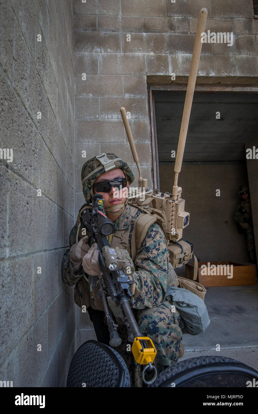 U.S. Marine Corps Lance Cpl. Robert Madrid, an infantryman with 3rd Battalion, 4th Marine Regiment, 1st Marine Division, wears a concept communication system during Urban Advanced Naval Technology Exercise 2018 (ANTX18) at Marine Corps Base Camp Pendleton, California, March 21, 2018. The Marines are testing next generation technologies to provide the opportunity to assess the operational utility of emerging technologies and engineering innovations that improve the Marine’s survivability, lethality and connectivity in complex urban environments. Armed Forces and civilians displaying courage bra Stock Photo