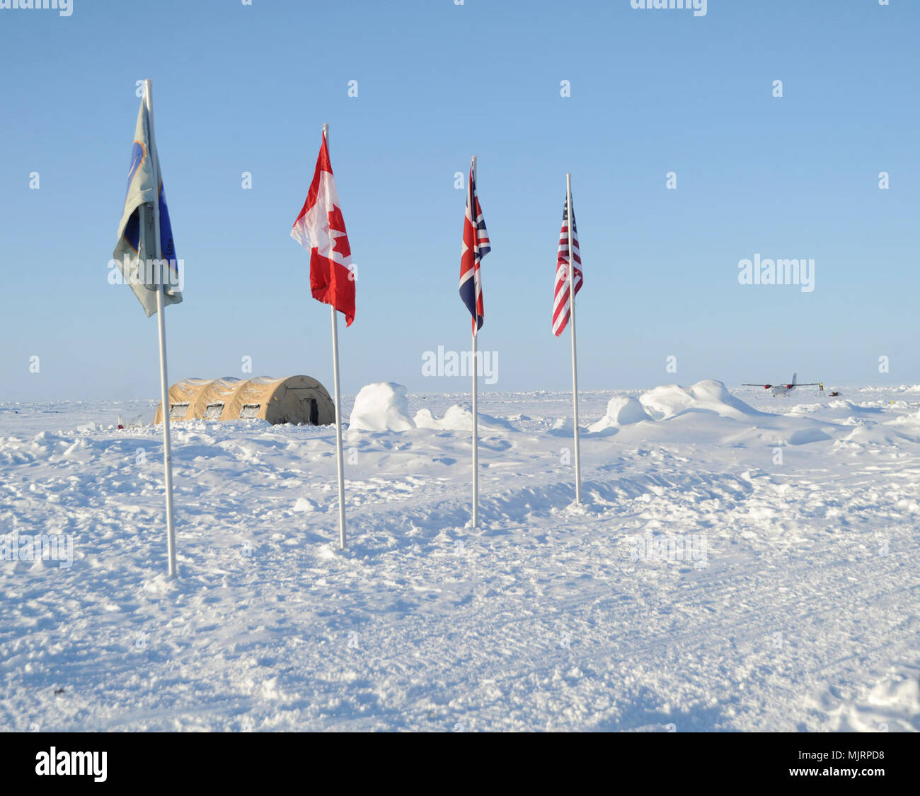 BEAUFORT SEA (March 21, 2018) A flag baring the Ice Camp Skate emblem is followed by flags representing each country participating in Ice Exercise (ICEX) 2018. ICEX 2018 is a five-week exercise that allows the Navy to assess its operational readiness in the Arctic, increase experience in the region, advance understanding of the Arctic environment, and continue to develop relationships with other services, allies and partner organizations. Armed Forces and civilians displaying courage bravery dedication commitment and sacrifice Stock Photo